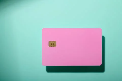 Closeup of a pink debit card with a microchip on a green table Stock Photos