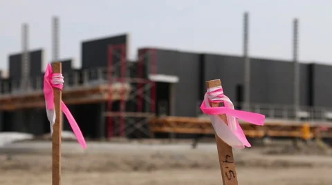 Closeup pink marker stakes at an empty commercial construction site Stock Footage 47576020