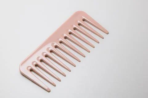 Closeup of pink wide-teeth comb isolated on white background Stock Photos
