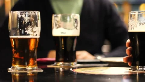 Closeup pints of draft beer of friends on background drinking in pub Video stock 140753018