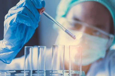 Closeup-pipette dropping a sample into a test tube in an experiment research  Stock Photos