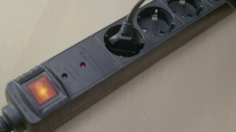 Closeup of plugging in cords into a black power strip while turning the elect Stock Footage 87014819