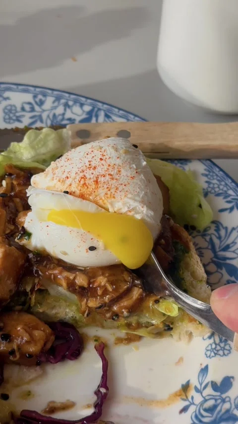 Closeup of poached egg served on toast with vibrant vegetables and spices 動画素材 333332835