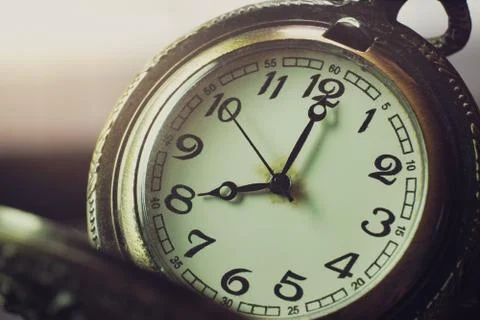 Closeup pocket watch on table and sunlight. At 8 am. o'clock in the morning. Stock Photos