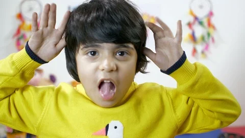 Closeup portrait of a boy mocking - facing the camera. Making funny faces Stock Footage 112107909