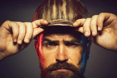 Closeup portrait of builder in hardhat. Handsome male architect or engineer i Stock Photos