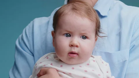 Closeup portrait of curious caucasian cute little baby with blue eyes looks Stock Footage 168106910