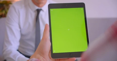 Closeup portrait of customer manager talking to client holding tablet with green Video stock 114001068