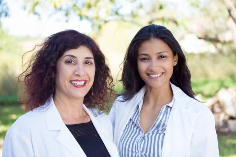 Closeup portrait of friendly, smiling confident female doctors, healthcare pr Stock Photos