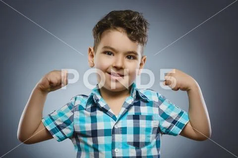 Closeup Portrait of Funny child. Strong kid showing his hand biceps muscles Stock Photos