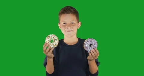 Closeup. portrait of a funny guy, having fun with colorful donuts against his Stock Footage 116715798