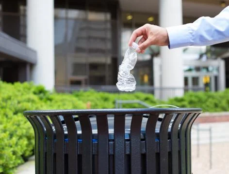 Closeup portrait, hand throwing plastic empty water bottle in recycling bin Stock Photos