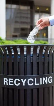 Closeup portrait, hand throwing plastic empty water bottle in recycling bin Stock Photos