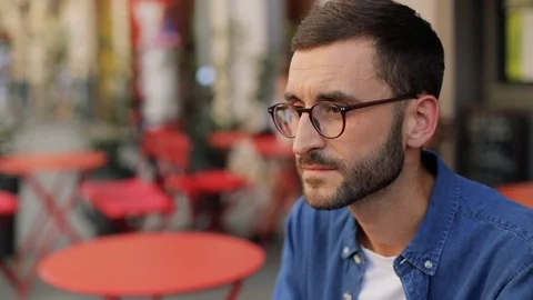 A closeup portrait of a handsome young man at the cafe - turning his head to the Stock Footage 81050458