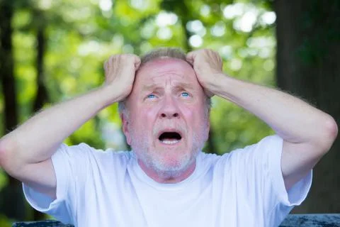 Closeup portrait, old guy with goatee in white shirt, frustrated, wide open m Stock-Fotos