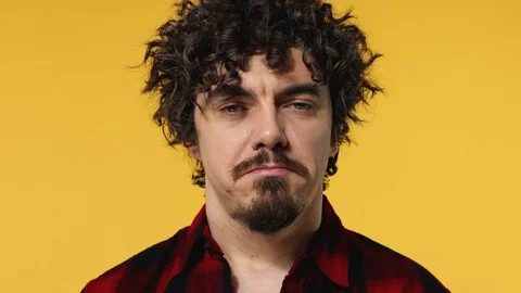 Closeup portrait of sad crying guy with curly hair isolated on yellow background Stock Footage 128878540