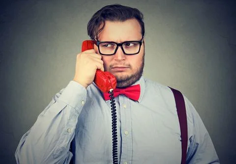 Closeup portrait of a serious grumpy looking businessman talking on telephone Stock Photos