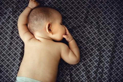Closeup portrait of sleeping on the grey bed in diaper innocence Stock Photos