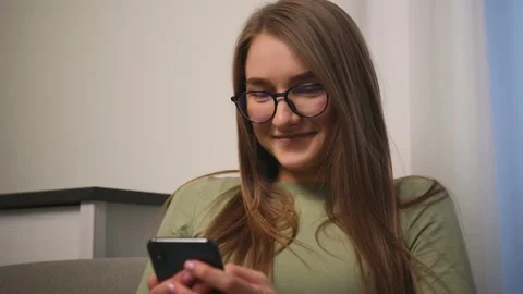 Closeup. Portrait of smiling attractive young woman in glasses use phone for Stock Footage 150586325