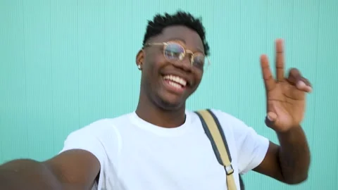 Closeup portrait of smiling young man taking a selfie on green wall background. Stock Footage 223128990