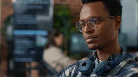 Closeup portrait of software engineer writing code fixing glasses and smiling Stock Photos