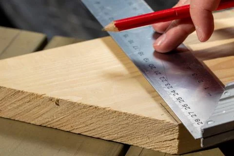 A closeup portrait of someone using a stainless steel L-square or snag to mea Foto stock