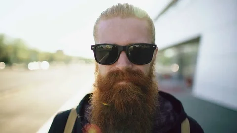 Closeup portrait of young bearded hipster man in sunglasses smiling and posing Stock Footage