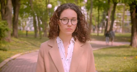 Closeup portrait of young long haired curly caucasian female student in glasses Video stock 109848159