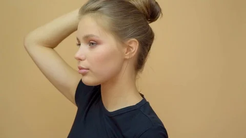Closeup portrait of young wooman posing to a camera with blowed out hair on grey Stock Footage 114741232