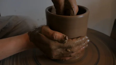 Closeup of potter's hand working behind a potter's wheel. Stock Footage 98514713