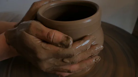 Closeup of potter's hand working behind a potter's wheel. Stock Footage 98514759