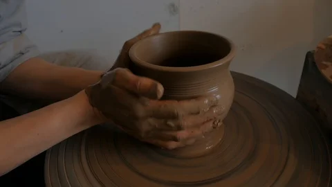 Closeup of potter's hand working behind a potter's wheel. Video stock 98514766