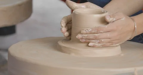 Closeup on potter's hands shaping clay on a spinning pottery wheel Stock Footage 114010167