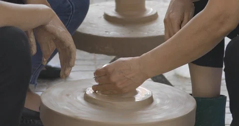 Closeup on potter's hands shaping clay on a spinning pottery wheel Stock Footage 114012548