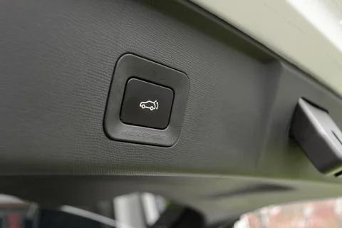Closeup power liftgate button inside car trunk shows modern vehicle control f Foto stock