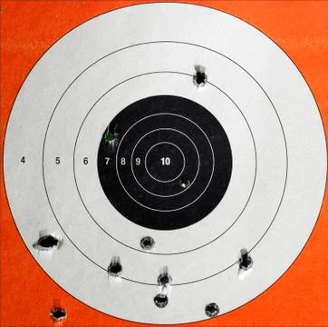 A closeup of a practice target used for shooting with bullet holes in it. Stock Photos