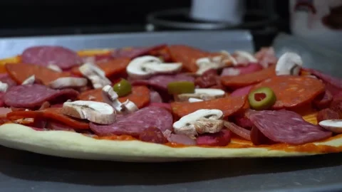 Closeup preparing homemade pizza in the kitchen with salami and pepperoni Stock Footage 164581007