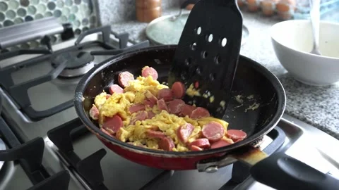 Closeup preparing scrambled eggs with sausage in a pan in the kitchen in the Video stock 172270145