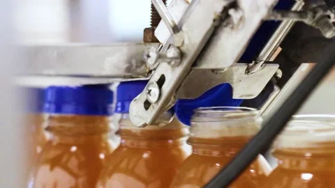 Closeup of the process of covering Fruit Juice factory bottles Stock Footage 242435758