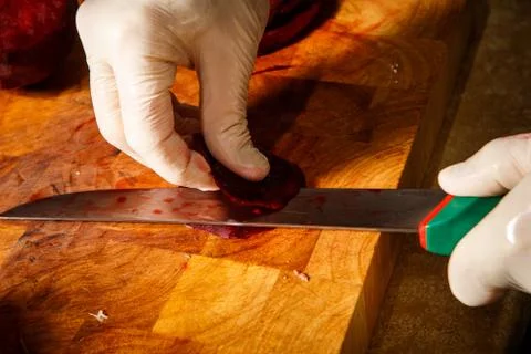 Closeup process of cutting beetroot on wooden cutting board Stock Photos