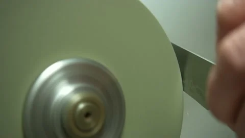 Closeup process of sharpening knife on round whetstone Stock Footage 237368506