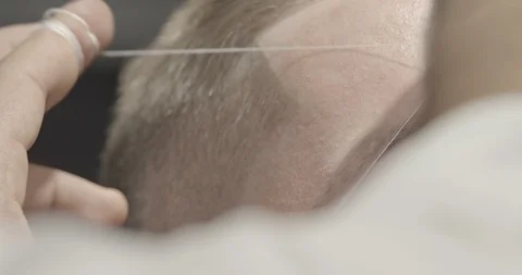Closeup of process of threading procedure in barber shop. Slow motion. Stock Footage 103160112