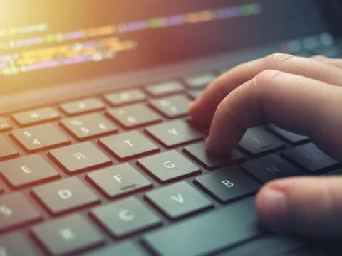 Closeup programmer coding on screen. Hands coding html and programming on lap Foto stock