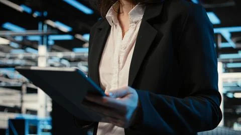 Closeup of programmer walking in data center, optimizing server load with tablet Stock-Fotos
