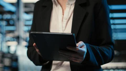 Closeup of programmer walking in data center, optimizing server load with tablet Stock-Fotos