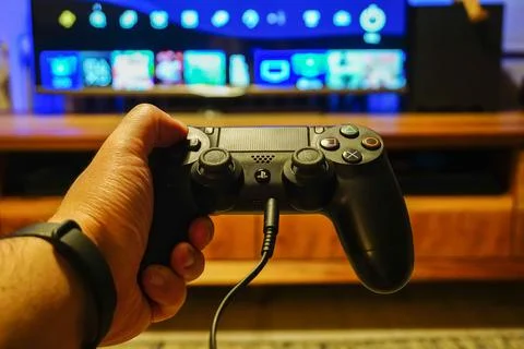 Closeup of a PS4 black controller DualShock 4 in a gamer's hand Stock Photos