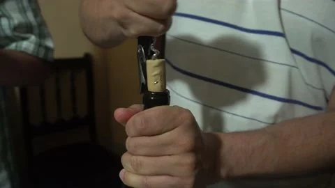 Closeup pulling the cork out of a wine bottle with a corkscrew Stock Footage 146676344