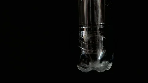 Closeup put water in the plastic bottle black background. Video stock 155024377