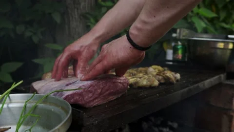 Closeup putting a cut of beef picanha on a grill with chicken wings with friends Stock Footage 170018151