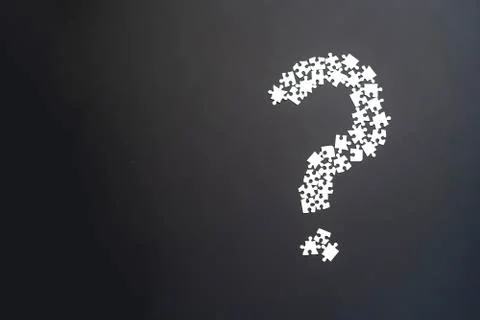 Closeup puzze question mark on dark background isolated Stock Photos